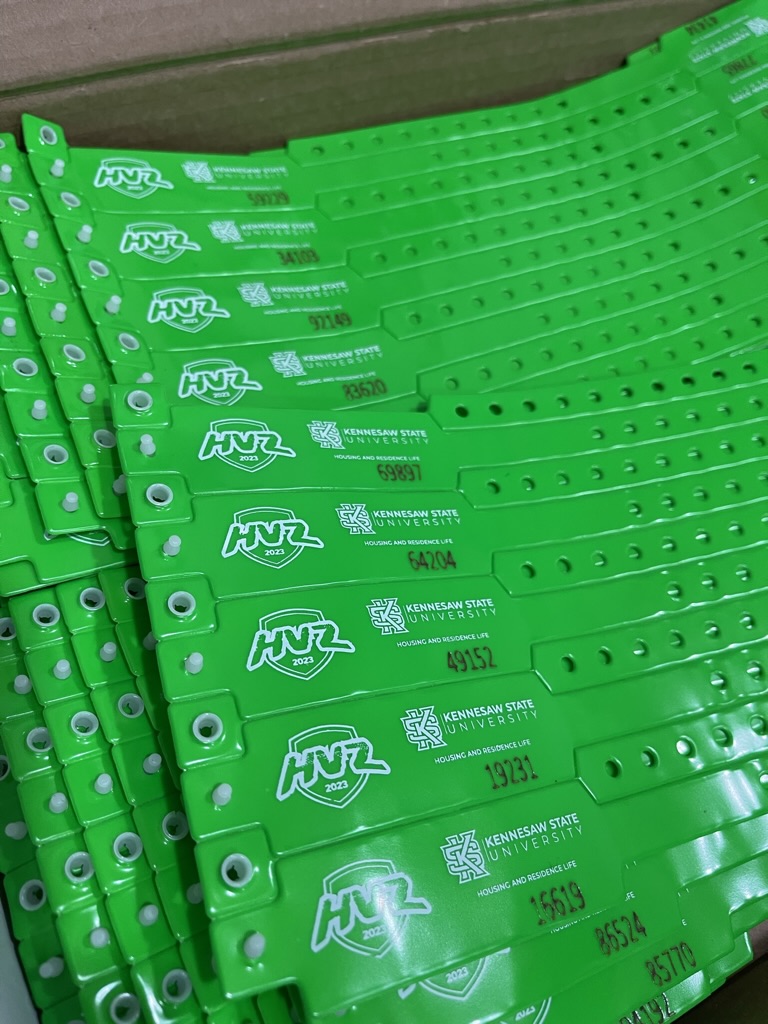 Green HVZ wristbands arranged for check-in